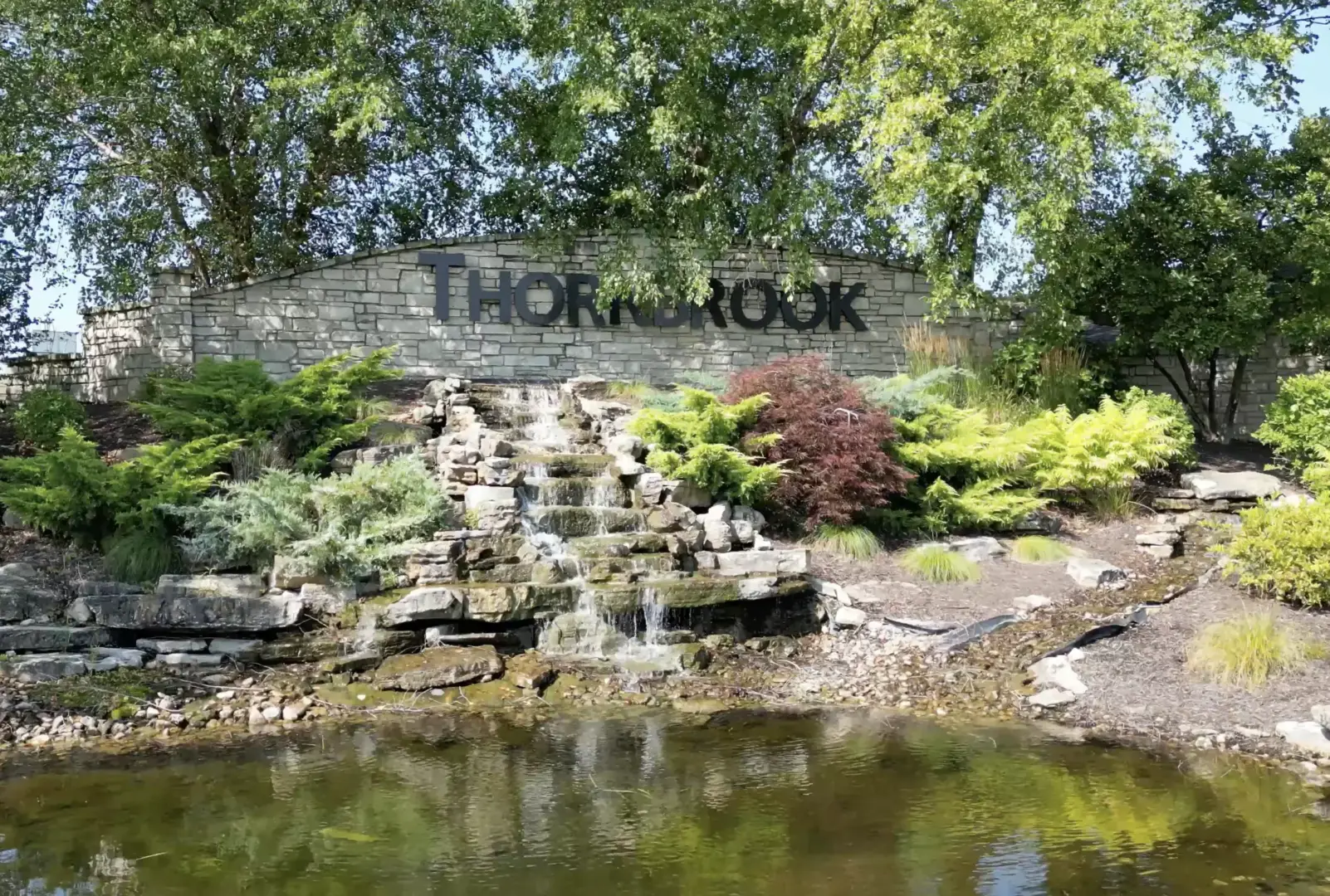 Picture of "ThornBrook" sign with a small waterfall in front