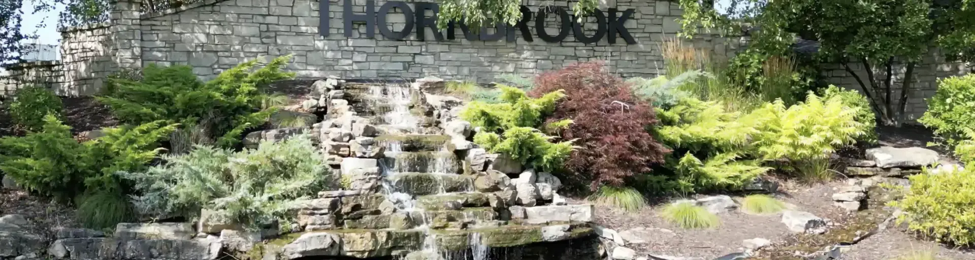 Picture of "ThornBrook" sign with a small waterfall in front